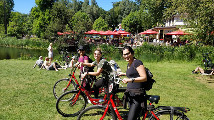 Image of group of women cycling in park in Amsterdam